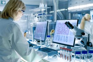 Senior Female Scientist Works with High Tech Equipment in a Modern Laboratory. Her Colleagues are Working Beside Her.